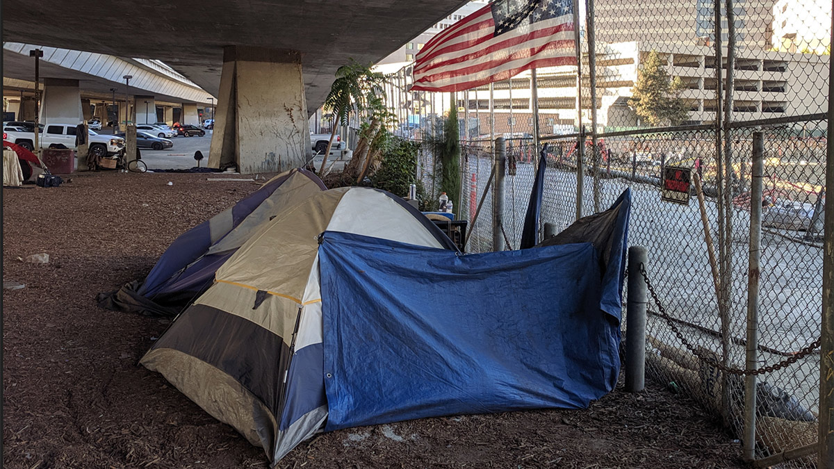 Homeless tents and flag under CA-87 in San Jose