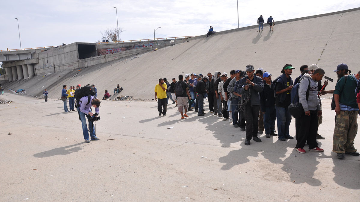 Immigrants lined up at a border area.