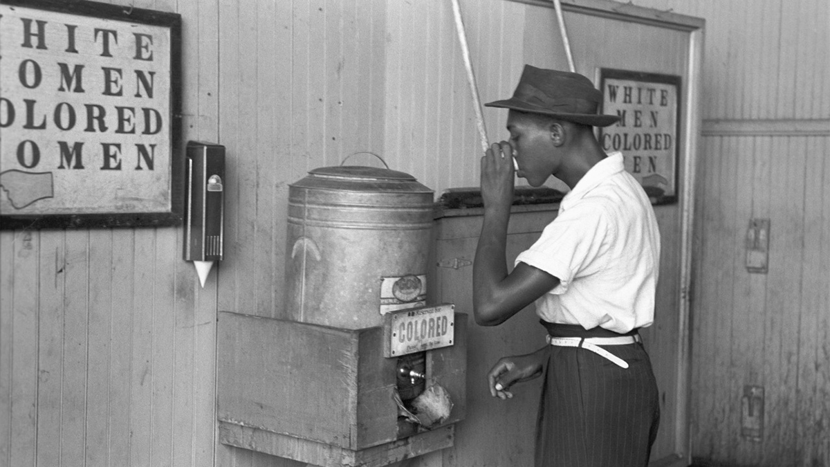 The race-centered state policies of the Jim Crow era are typified by segregated drinking fountains shown in this image.