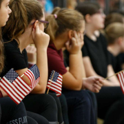 American students hold miniature flags during a school event