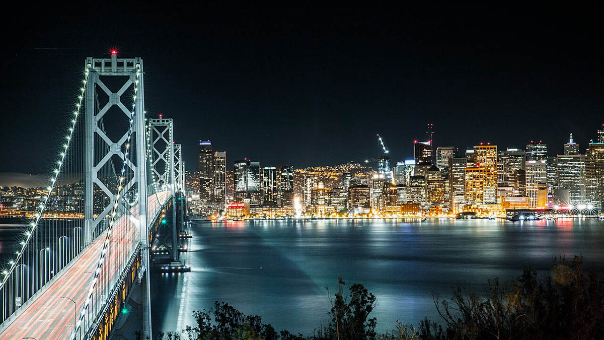 View across a bridge towards downtown San Francisco at night.